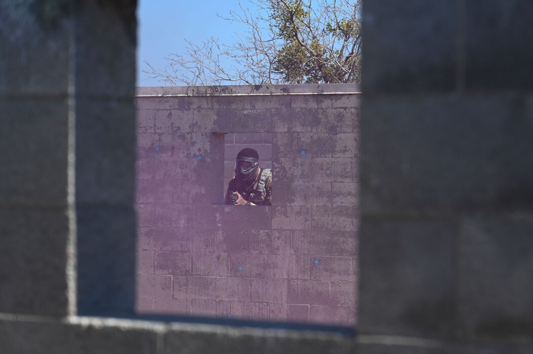 Cadet from Angelo State University Air Force ROTC participates in a simulated combat scenario where he shoots through a smokebomb as part of an annual field training exercise at Goodfellow Air Force Base, March 1, 2024. Cadets practiced expeditionary skills with paintball guns as part of the field training exercise. (U.S. Air Force Photo by Airman James Salellas)