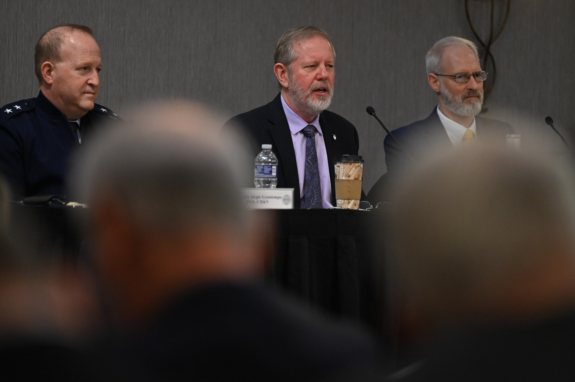 Image of people speaking at conference.