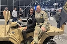 Female Civilian and Female Soldier sit on an Army All-Terrain vehicle on display at the Chicago Auto Show