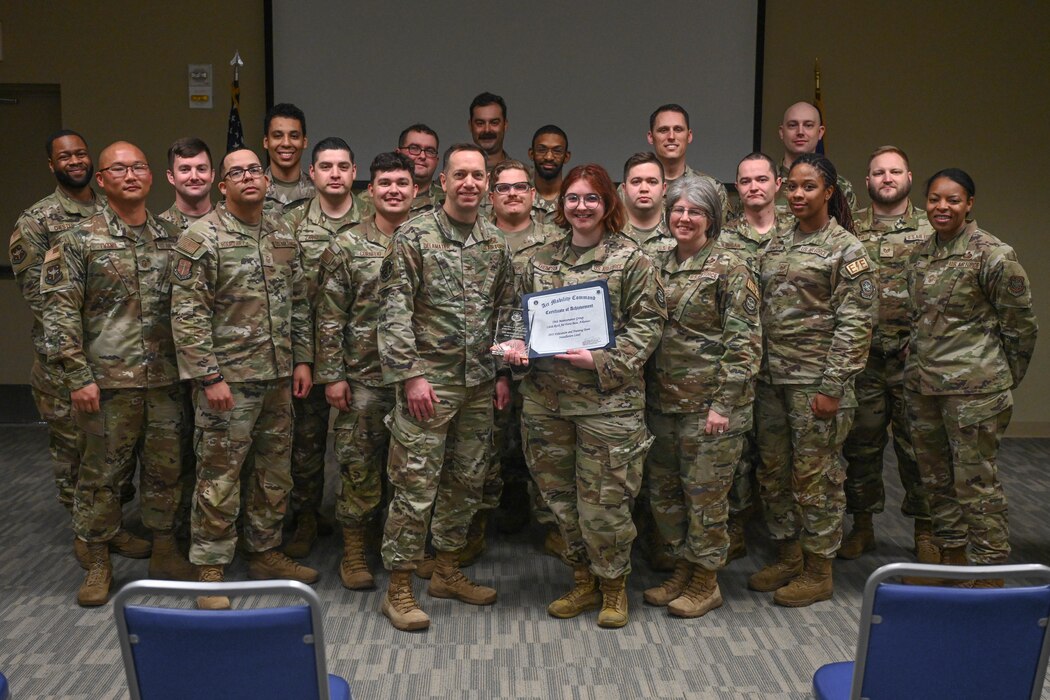 Col. Jason Delamater, Air Mobility Command director of manpower, personnel, and services, presents the 19th Maintenance Group with the 2023 Education and Training Team Award at Little Rock Air Force Base, Arkansas, Mar. 4-5, 2024.