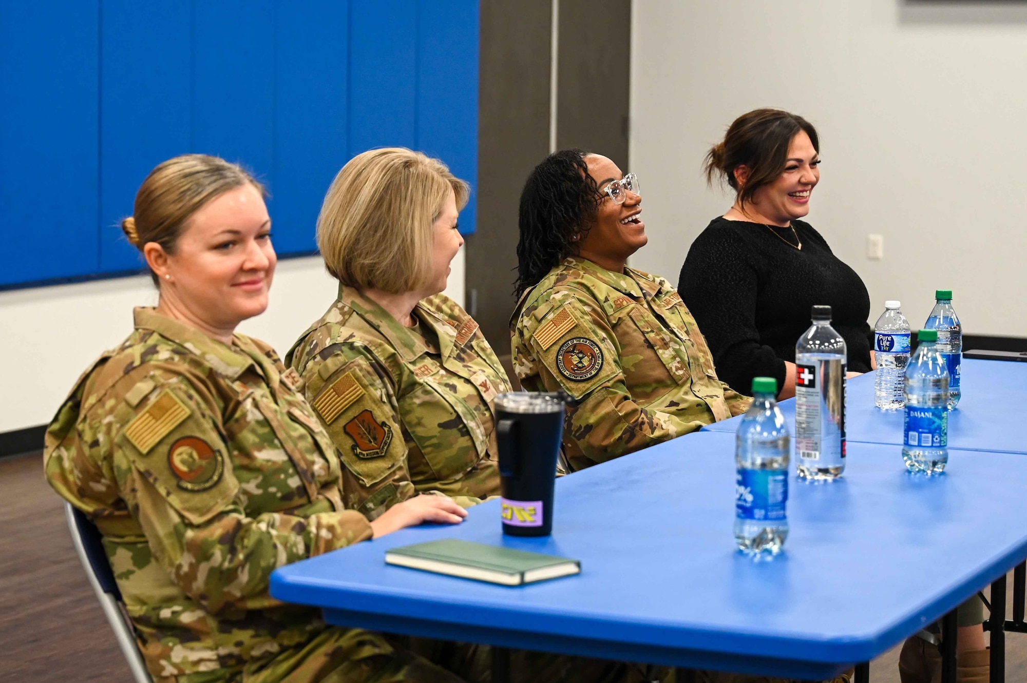 The panel of women at Coffee and Connect laugh as Chief Master Sgt. Debra Spivey, Equal Opportunity Career Field Manager, tells her story, at Altus Air Force Base, Oklahoma, March 6, 2024. Spivey explained how hard the strain of military life can be on a family and how her and her active-duty husband have made it work for two decades. (U.S. Air Force photo by Airman 1st Class Kari Degraffenreed)