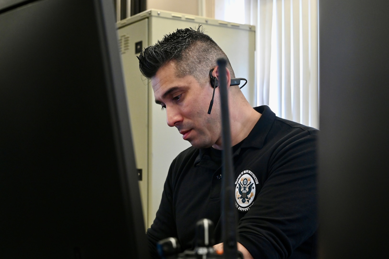 U.S. Army Sgt. 1st Class Daniel Garcia, operations noncommissioned officer and GIS modeler, 33rd WMD-CST, monitors radio communication at the D.C. Armory, March 7, 2024.  The 33rd WMD-CST was strategically positioned to respond effectively with D.C. Fire, U.S. Secret Service, U.S. Capitol Police, and CBRNE Enhanced Response Force Packages (CERFP) units.