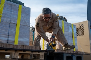 A loadmaster prepares a bundle of humanitarian aid destined for an airdrop over Gaza.