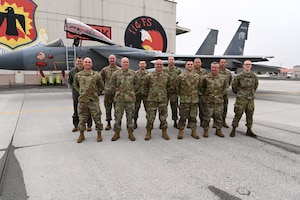 group of Airmen in front of F-15 Eagle