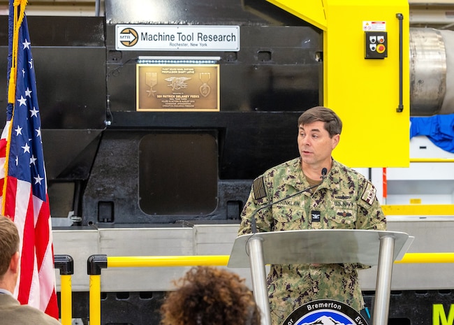 Capt. JD Crinklaw, commander, Puget Sound Naval Shipyard & Intermediate Maintenance Facility in Bremerton, Washington, delivers remarks, Feb. 26, 2024, during a dedication ceremony for a new propulsion shaft lathe, honoring Special Warfare Operator 1st Class (Navy SEAL) Patrick D. Feeks, who was killed in Afghanistan Aug. 16, 2012. (U.S Navy photo by Jeb Fach)