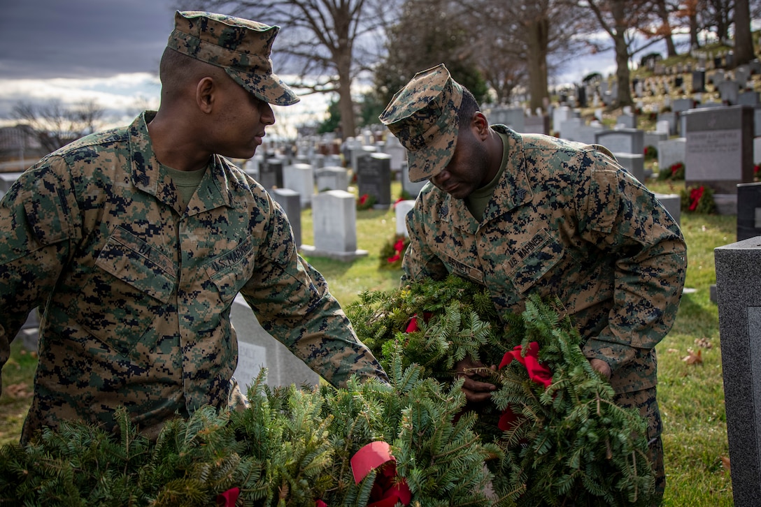 Sergeant Moussa Ba, water support technician, and Sgt. Timothy D. Bennet Jr., electrician, Headquarters and Service Company, clear wreaths from gravesites at Arlington National Cemetery on Jan 20, 2023. Over the weekend, Marine Barracks Washington had the solemn honor of participating in clearing wreaths from over 250,000 gravesites in remembrance and honor of our nation’s fallen service members and their families. (U.S. Marine Corps photo by Cpl. Mark Morales)