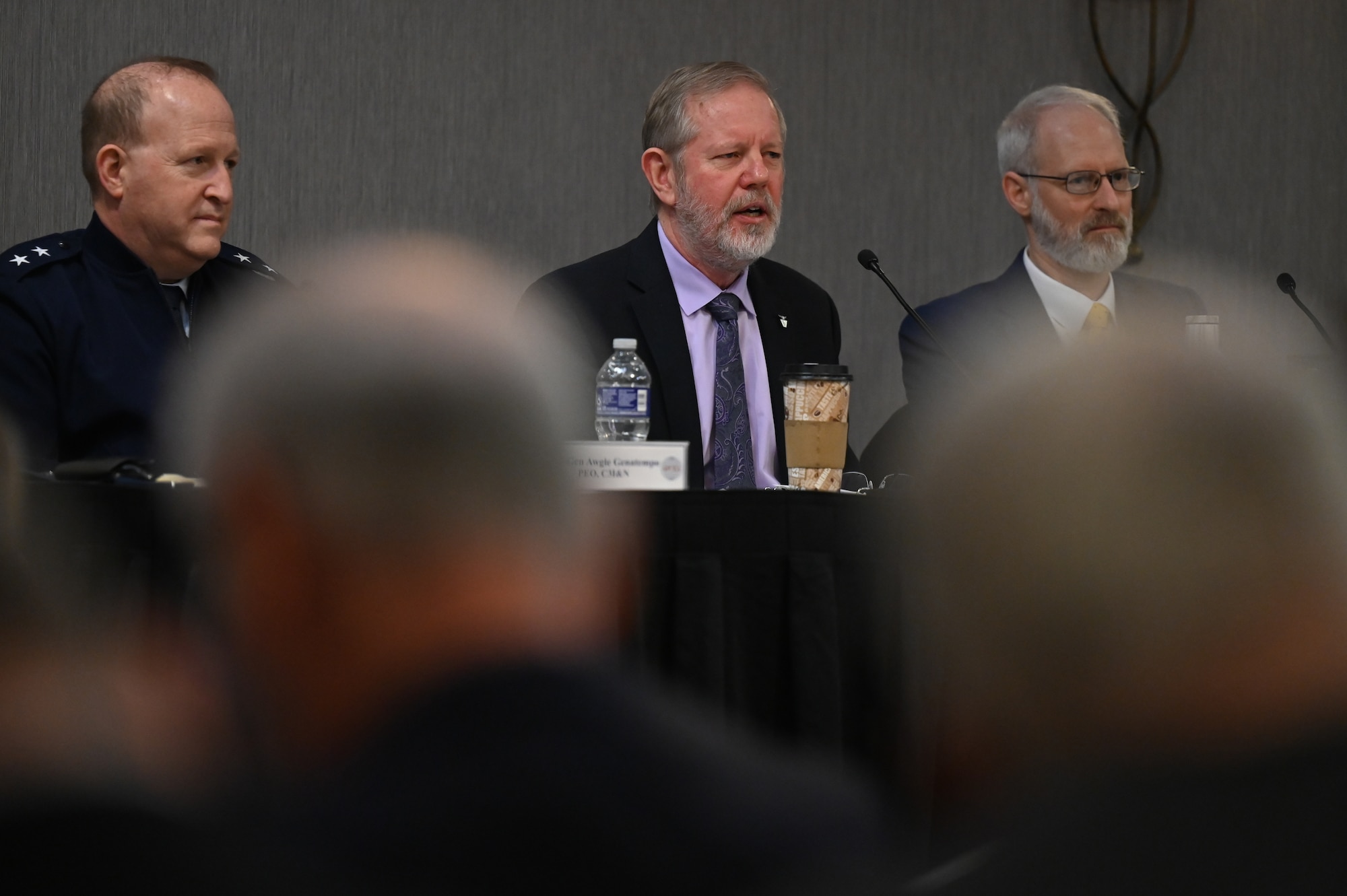 Image of people speaking at conference.