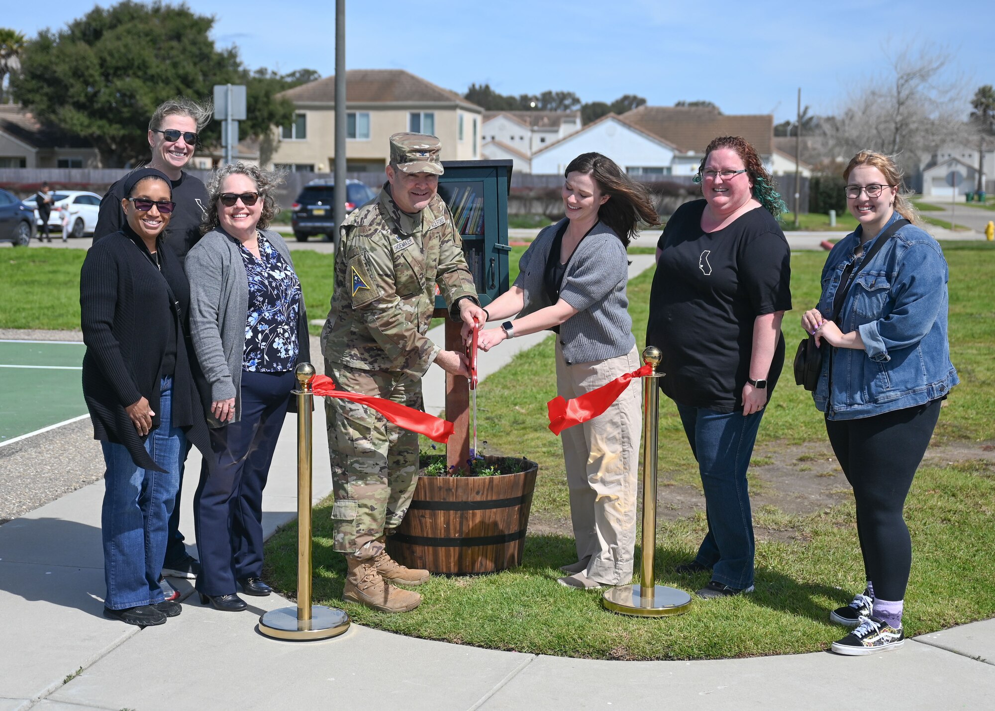 Col. Shoemaker and spouses cut the ribbon to the little library.