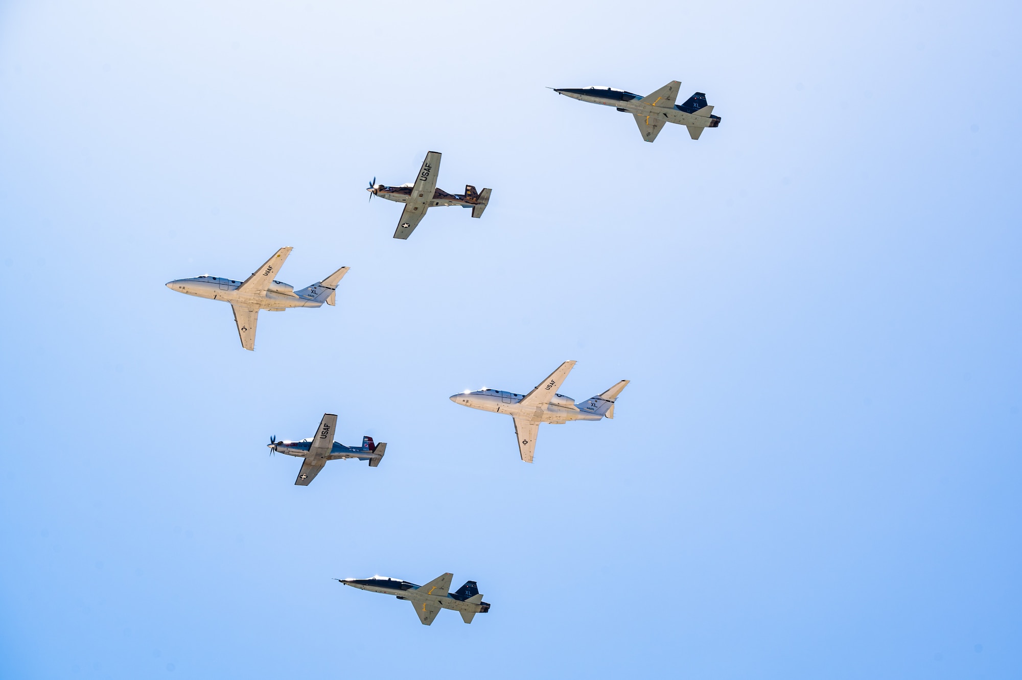 Six U.S. Air Force aircraft perform a flyover at Laughlin Air Force Base, Texas, March 9, 2024. The formation included two T-1A Jayhawks, two T-6A Texan II’s and two T-38C Talons. The flyover was performed during the Fiesta of Flight airshow at show center following the national anthem. (U.S. Air Force photo by Airman 1st Class Keira Rossman)