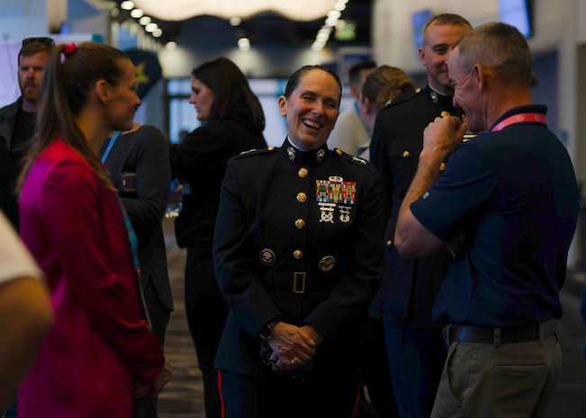 Sally Roberts, left, Chief Executive Officer and Co-founder of Wrestle Like A Girl, and, U.S. Marine Corps Ret. Col. David Fallon, right, speak with U.S. Marine Corps Major General Roberta L. Shea, center, Legislative Assistant to the Commandant of the Marine Corps, Office of Legislative Affairs, Headquarters Marine Corps, at the National Collegiate Women’s Wrestling Championships, Cedar Rapids, IA., March 8, 2024. The National Collegiate Women’s Wrestling Championship works with the Wrestle Like A Girl to promote female empowerment through the sport of wrestling.  (U.S. Marine Corps photo by Cpl. Collette Hagen)