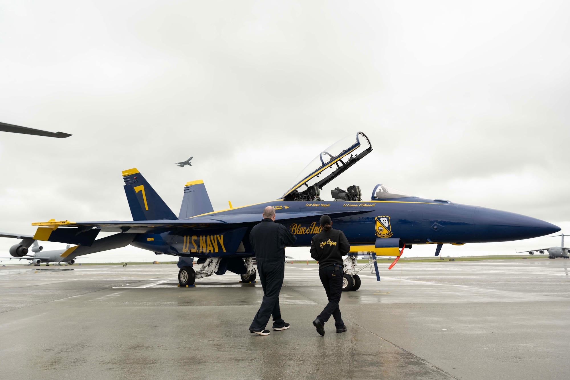 A military member and a civilian walk out to a military jet