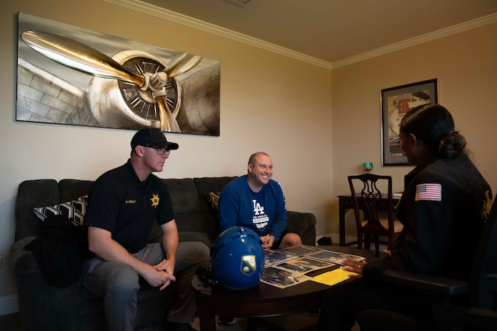 Three people have a conversation in a room