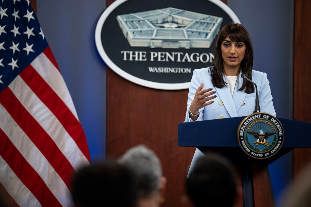A woman stands behind a lectern.