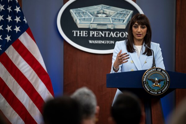 A woman stands behind a lectern.