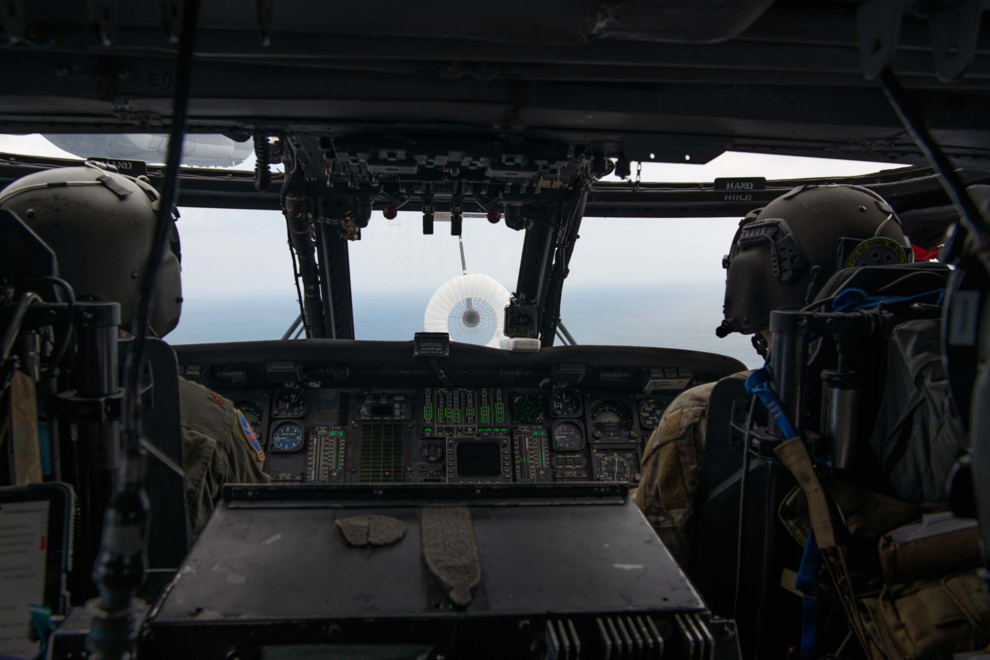 Helicopter pilots connect their aircraft to a refueling drogue.