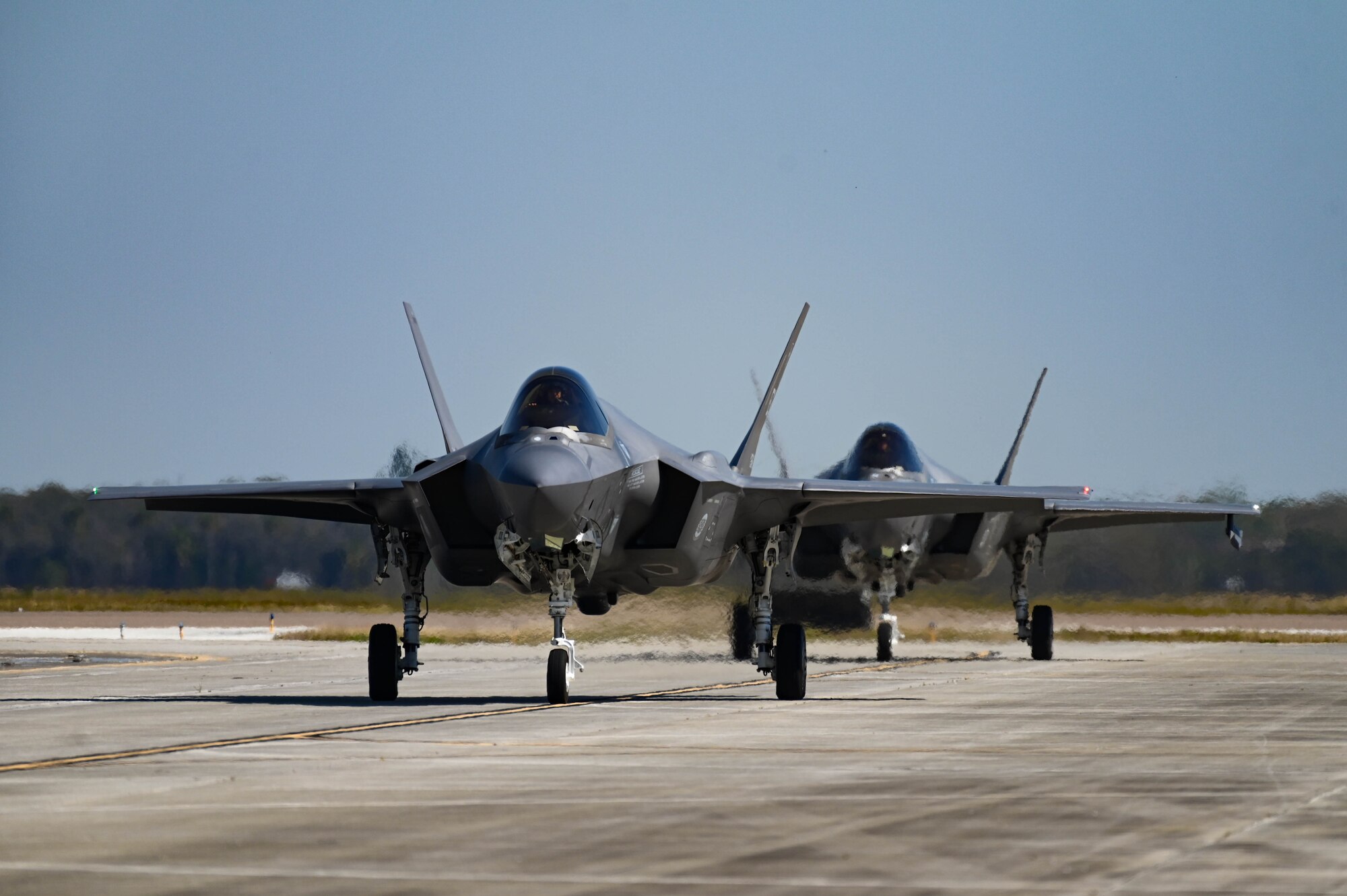 A photo of two F-35s on flightline.