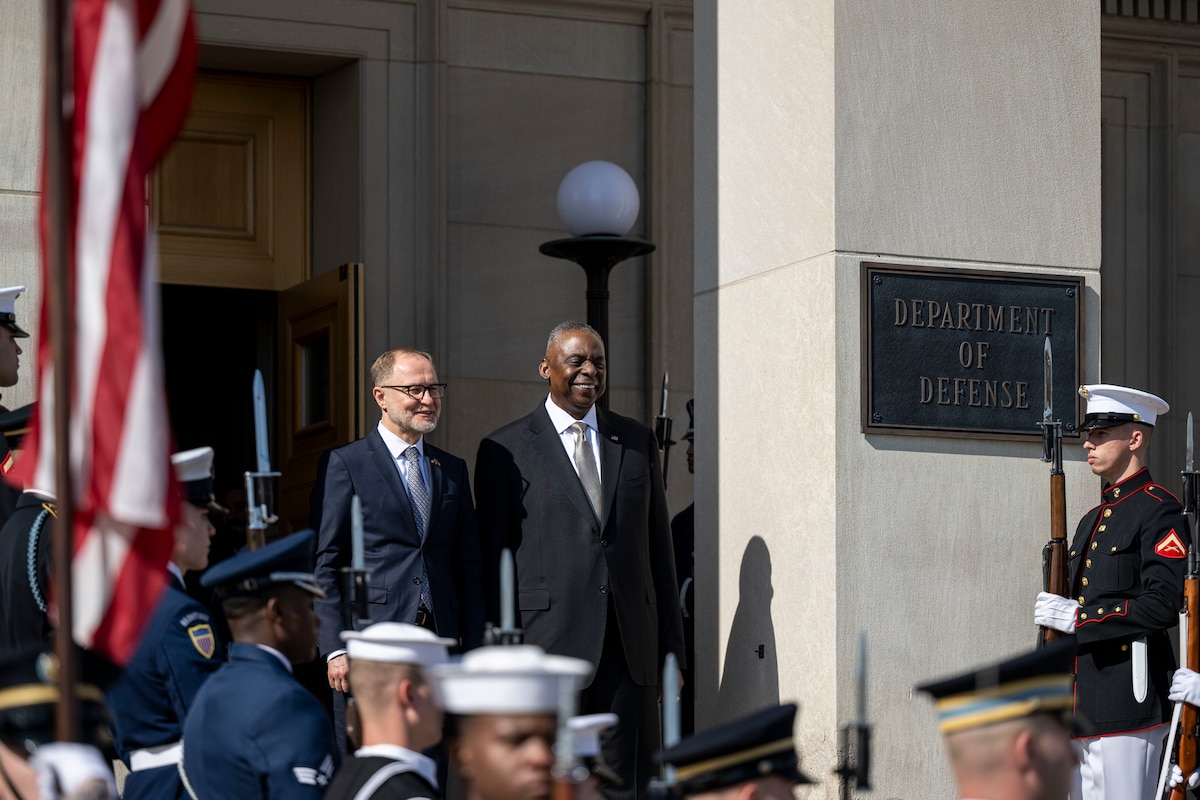 Two defense leaders stand on the steps of the Pentagon during a ceremony.