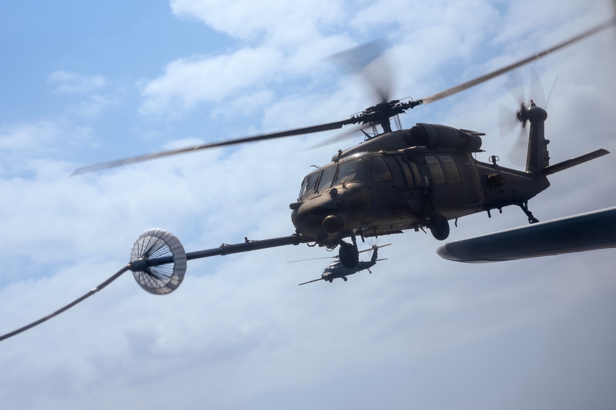 A U.S. Air Force HH-60G Pave Hawk assigned to the 33rd Rescue Squadron conducts helicopter air-to-air refueling with a U.S. Marine Corps KC-130J Super Hercules assigned to Marine Aerial Refueler Transport Squadron (VMGR) 152 during a joint search and rescue training mission over the Pacific Ocean, March 13, 2024. HAAR operations act as a force extender, keeping rescue assets in the air longer. (U.S. Air Force Photo by Staff Sgt. Jessi Roth)