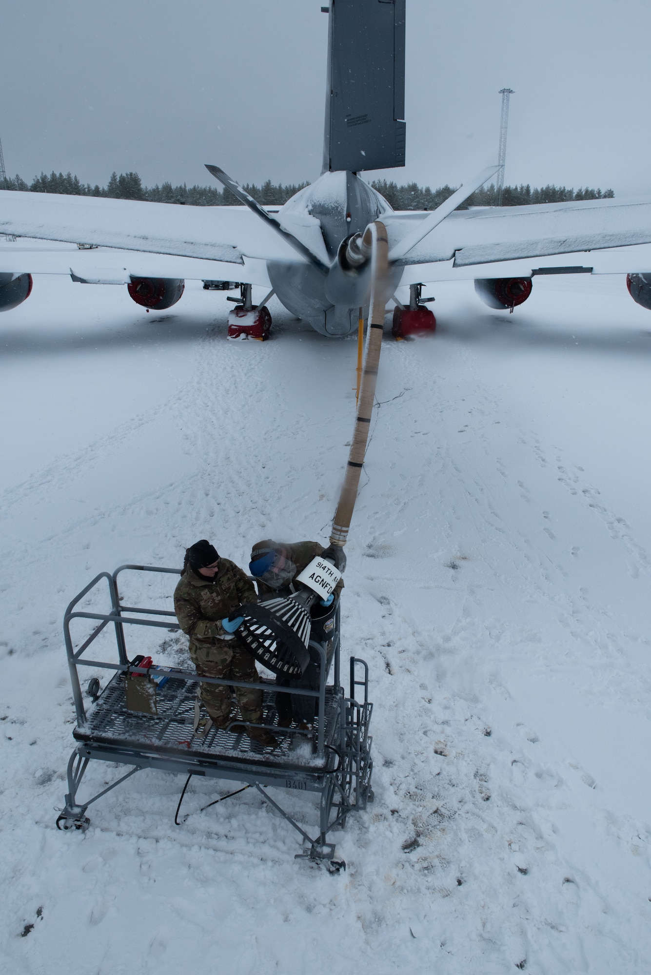 Airmen work on a KC-135 in the snow