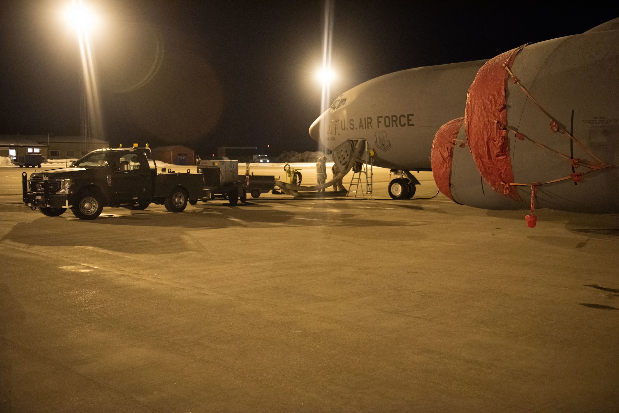 Airmen work on a KC-135 Stratotanker at night