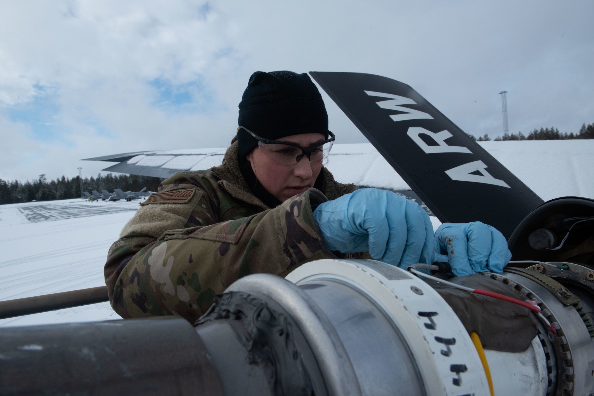 Airmen works on aircraft in the snow