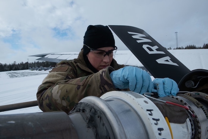 Airmen works on aircraft in the snow