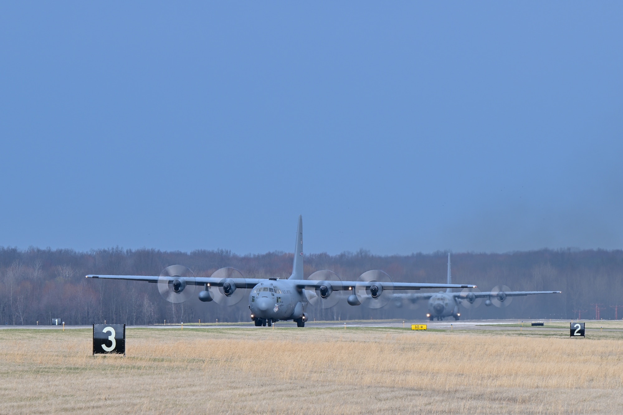A pair of C-130H Hercules aircraft assigned to the 910th Airlift Wing prepare to take off as they depart Youngstown Air Reserve Station, Ohio, for a local training flight, March 14, 2024.