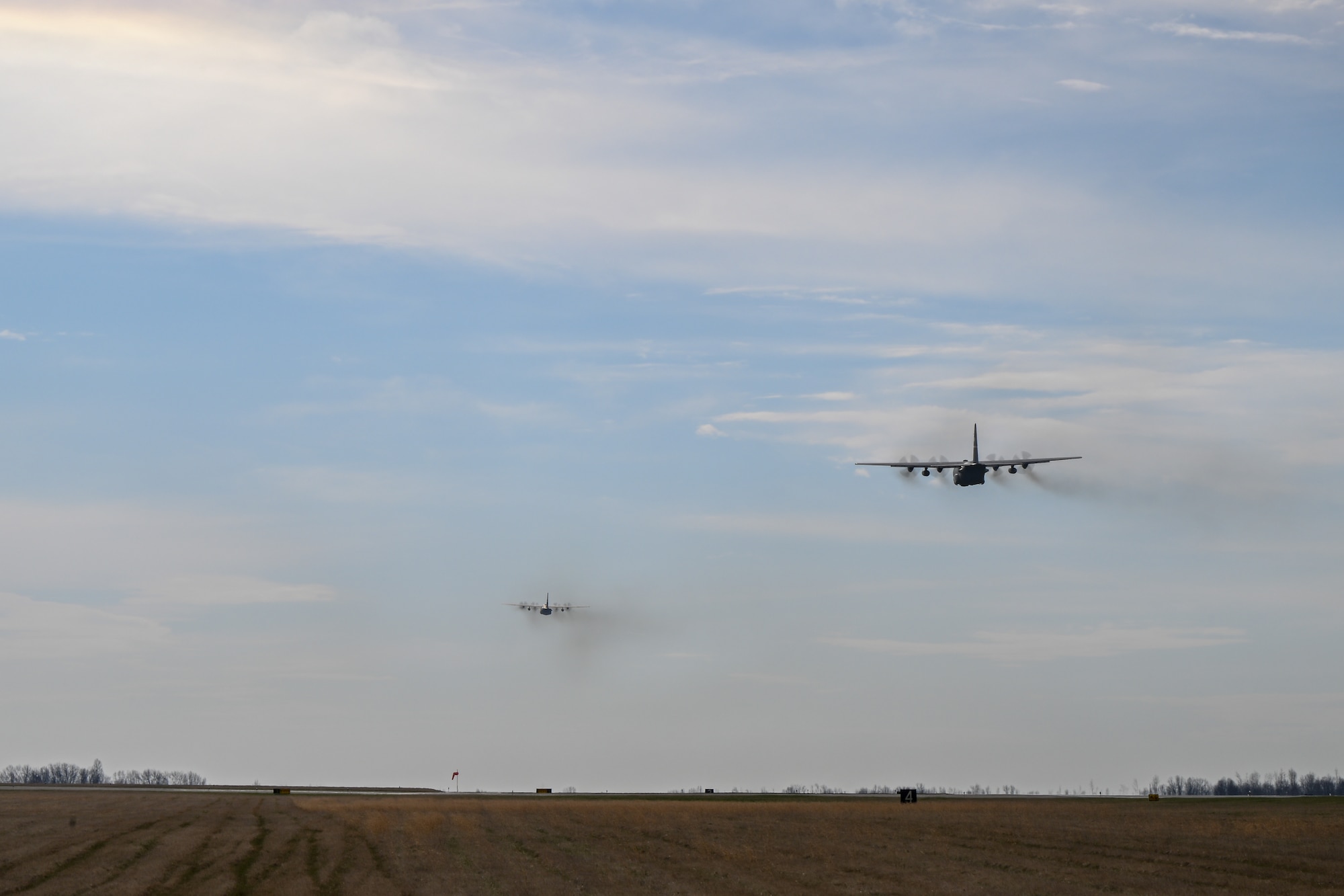 A pair of C-130H Hercules aircraft assigned to the 910th Airlift Wing soar toward the horizon after departing Youngstown Air Reserve Station, Ohio, for a local training flight, March 14, 2024.