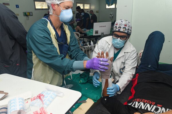 Reynaldo Muñoz, a 19-year-old Honduran resident, shows medical personnel that he can extend his left index finger on his own after an operation in the trauma bay of Hospital Nacional Mario Catarino Rivas mission on Feb. 27, 2024. EMU 10 G conducted its first GHE to enhance expeditionary core skills and knowledge exchange with Honduran healthcare professionals in a limited resource environment, Feb. 17 – March 2, 2024.