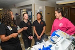 Dr. Angelia Washington, Abigail Brown, and Madison Pankey with Lejeune High School discuss health care delivery with NMCCL Nurse Brittany Chapman (pictured right) in the Intensive Care Unit of Naval Medical Center Camp Lejeune on March 5, 2024. Brown and Pankey are enrolled in the high school’s Health Sciences/Nurse Aide I Program led by Washington, a nurse educator and founder of the program.