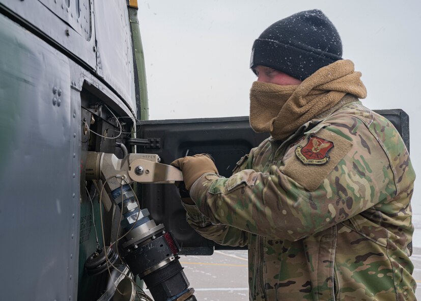 U.S. Air Force Staff Sgt. Michael Norris, 54th Helicopter Squadron (54th HS) evaluator flight engineer, connects a fuel hose to a UH-1N Iroquois at Minot Air Force Base, North Dakota, March 7, 2024. The 54th HS and their fleet of UH-1Ns provide rapid security response capabilities to Minot AFB’s missile fields. (U.S. Air Force photo by Airman 1st Class Kyle Wilson)