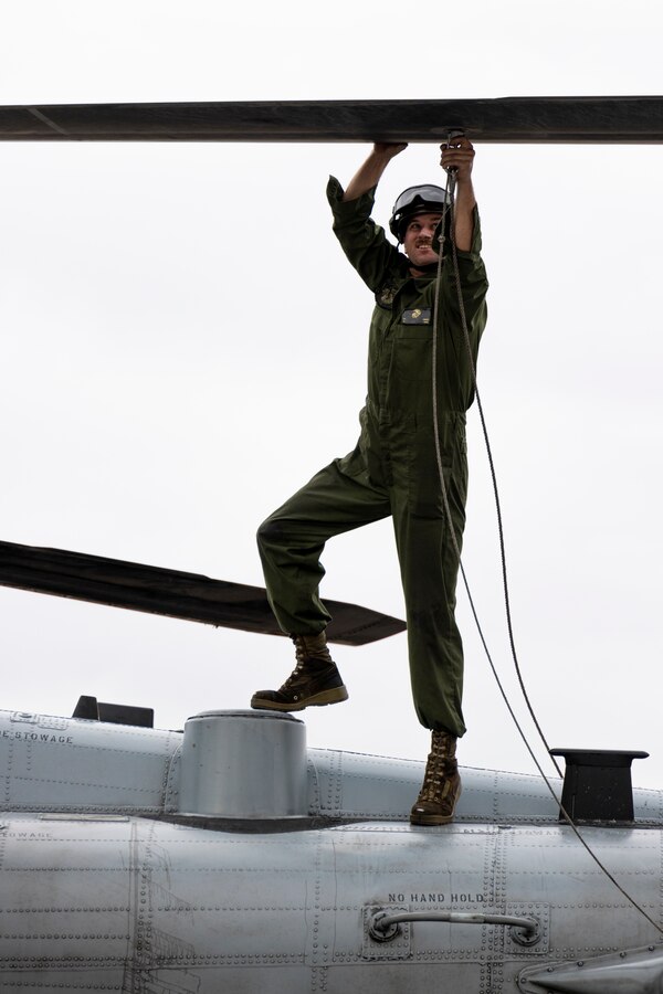 U.S. Marine Corps Cpl. Kenneth Carter, a CH-53E Super Stallion mechanic with Marine Heavy Helicopter Squadron (HMH) 462, Marine Aircraft Group 16, 3rd Marine Aircraft Wing, attaches a rope to a CH-53E Super Stallion helicopter rotor blade at Lake Havasu City, Arizona, Feb. 26, 2024. HMH-462 conducted unit deployment training to increase combat effectiveness, build flight leadership, and enhance aircrew proficiency. (U.S. Marine Corps photo by Lance Cpl. Jackson Rush)