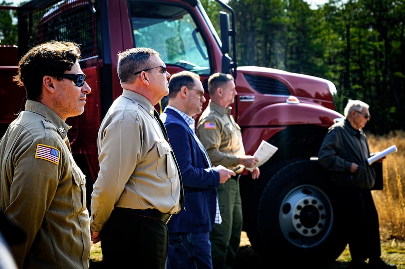 Members of the New Jersey Department of Environmental Protection and the New Jersey Forest Fire Service listen to opening remarks during a firebreak demonstration in Manchester Township, N.J., March 13, 2024. Officials toured a strategic forest fuel break in Manchester Township, Ocean County, one of three wildfire resilience projects in the Pinelands funded through the U.S. Department of Defense’s Readiness and Environmental Protection Integration Challenge Program. REPI facilitates long-term partnerships to improve resilience to climate change, preserve wildlife habitats and natural resources, and promote sustainable land uses near military installations and ranges. (U.S. Air Force photo by Senior Airman Matt Porter)