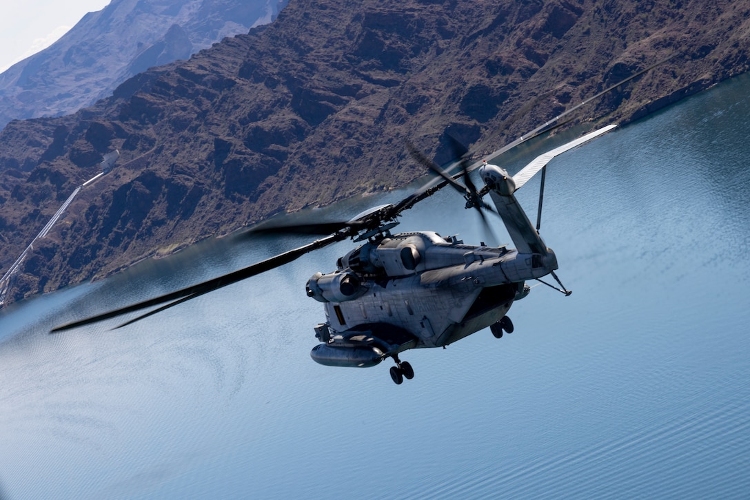 A U.S. Marine Corps CH-53E Super Stallion helicopter assigned to Marine Heavy Helicopter Squadron (HMH) 462, Marine Aircraft Group 16, 3rd Marine Aircraft Wing, flies over Lake Havasu during a resupply flight at Lake Havasu City, Arizona, Feb. 27, 2024. HMH-462 conducted unit deployment training to increase combat effectiveness, build flight leadership, and enhance aircrew proficiency.  (U.S. Marine Corps photo by Lance Cpl. Jackson Rush)