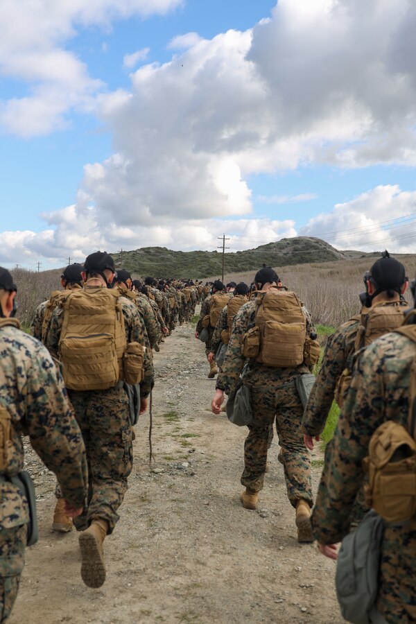 U.S. Marines with Marine Aviation Logistics Squadron 39, Marine Aircraft Group 39, 3rd Marine Aircraft Wing, conduct a chemical, biological, radiological and nuclear training hike at Camp Pendleton, California, March 1, 2024.  MALS-39 conducted the hike to promote squadron comradery while fulfilling annual training requirements and facilitating CBRN protective procedures and readiness. (U.S. Marine Corps photo by Lance Cpl. Nicholas Johnson)