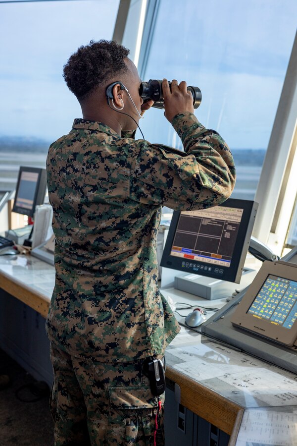 U.S. Marine Corps Cpl. Raillan Burn, an air traffic control specialist with Headquarters and Headquarters Squadron, Marine Corps Air Station Miramar, observes the flight line from the air traffic control tower at MCAS Miramar, California, March 5, 2024. Air traffic controllers coordinate with pilots to maintain and oversee the safe, orderly, and expeditious flow of air traffic operations in control zones, expeditionary airfields, or remote area landing sites. (U.S. Marine Corps photo by Sgt. Sean Potter)