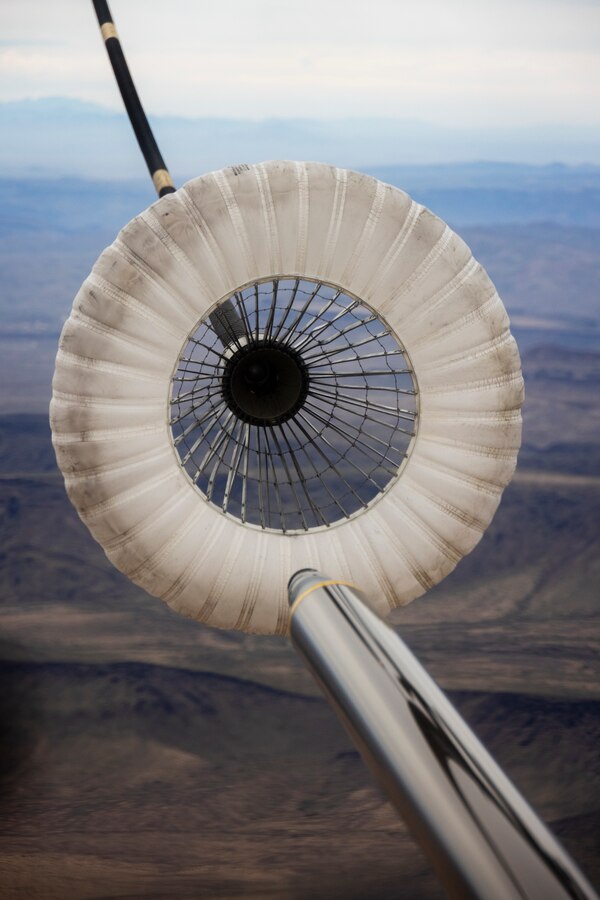 The refueling probe of a U.S. Marine Corps CH-53E Super Stallion helicopter assigned to Marine Heavy Helicopter Squadron (HMH) 462, Marine Aircraft Group 16, 3rd Marine Aircraft Wing, connects with the drogue of a U.S. Air Force HC-130J Combat King II assigned to the 79th Rescue Squadron, 563rd Rescue Group, 355th Rescue Wing, during joint air-to-air refueling near Lake Havasu City, Arizona, Feb. 26, 2024. The “Heavy Haulers” of HMH-462 conducted air-to-air refueling during unit deployment training to enhance aircrew proficiency and increase combat effectiveness. (U.S. Marine Corps photo by Lance Cpl. Jackson Rush)