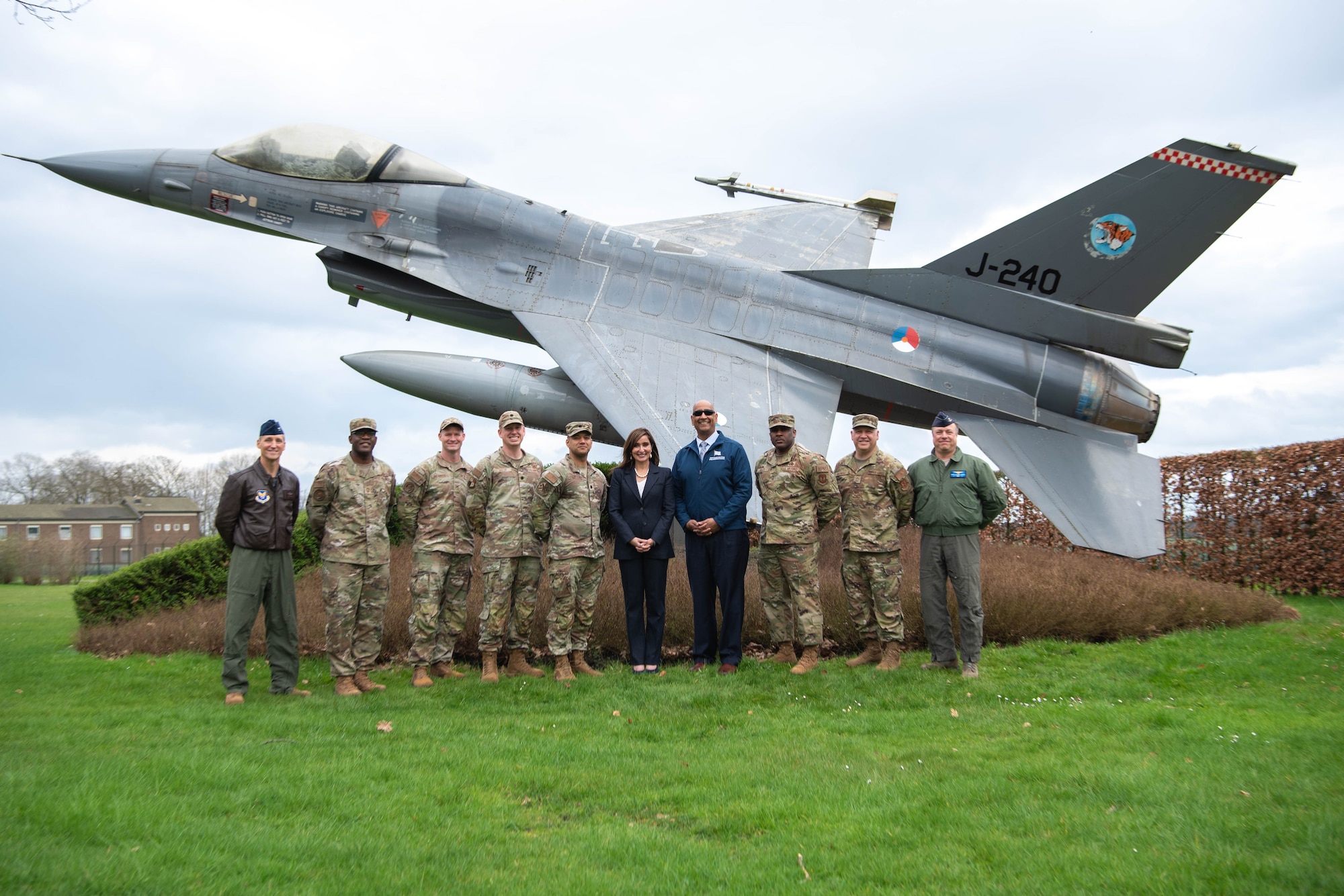 U.S. Ambassador to the Netherlands, Assistant Secretary of the Air Force for Energy, Installations, and Environment, and Airmen assigned to the 703rd Munitions Support Squadron pose in front of an F-16 static display.