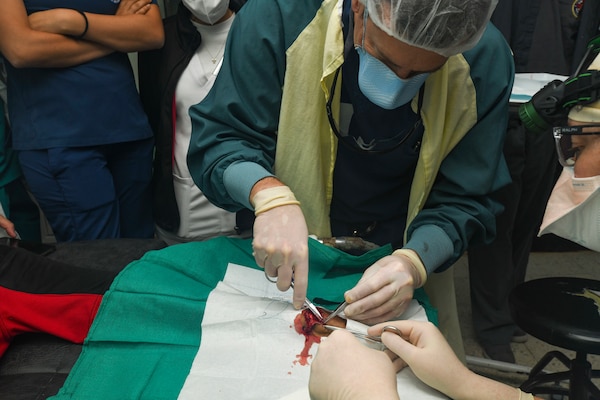 Capt. Bradley Deafenbaugh, an orthopedic surgeon assigned to Expeditionary Medical Unit 10 G – Rotation 16, sutures Renaldo Muñoz’s left index finger extensor tendon during an operation in the trauma bay of Hospital Nacional Mario Catarino Rivas during a Global Health Engagement mission on Feb. 27, 2024. EMU 10 G conducted its first GHE to enhance expeditionary core skills and knowledge exchange with Honduran healthcare professionals in a limited resource environment, Feb. 17 – March 2, 2024.