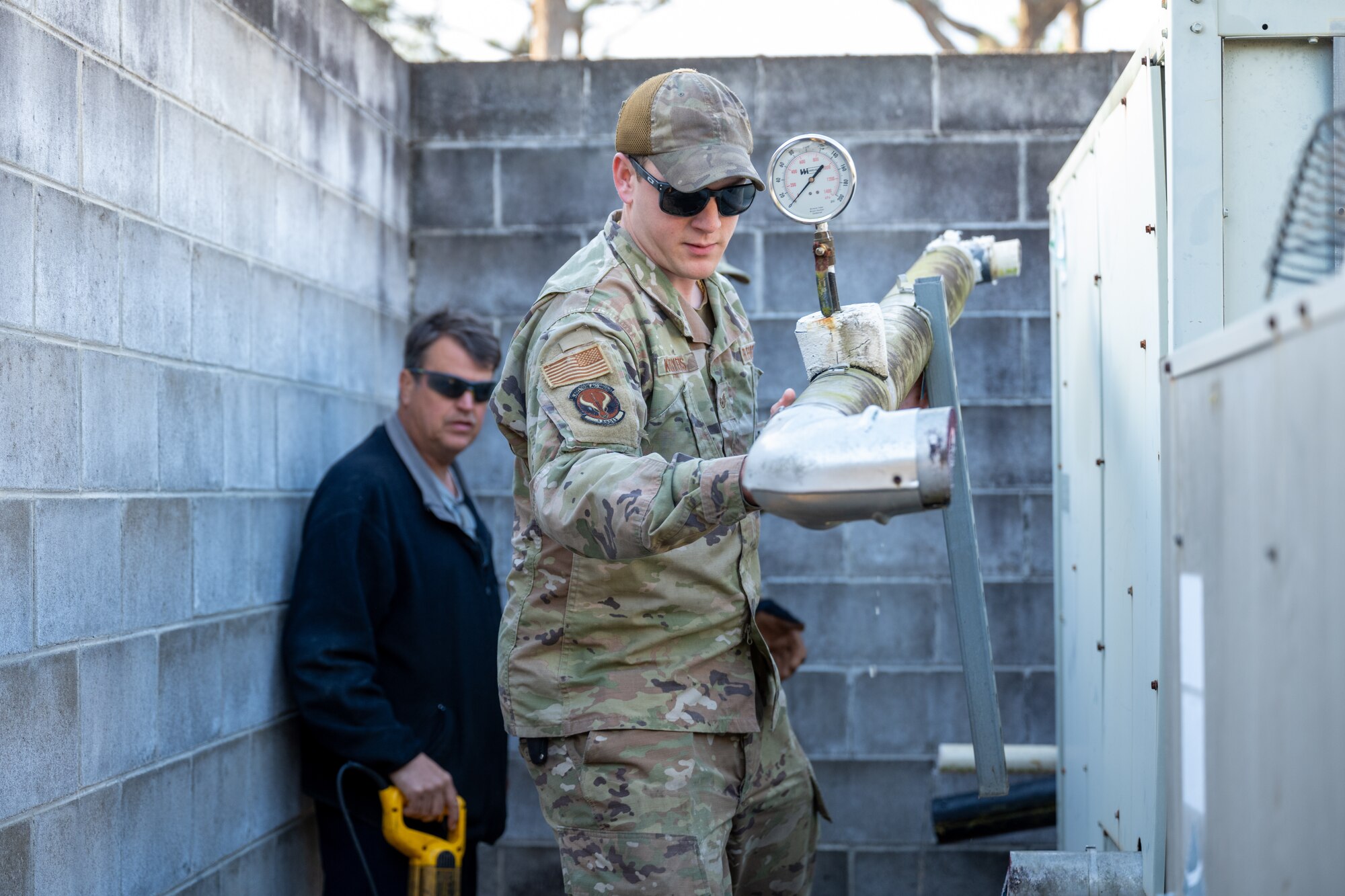 U.S. Air Force Staff Sgt. Cody Kooyers, a 1st Special Operations Civil Engineer Squadron Heating, Ventilation and Air Conditioning craftsman, carries an old pipe while replacing a chiller at Hurlburt Field, Florida, March 13, 2024. Replacing the chiller provides the Chapel with a more reliable air conditioning system to ensure Air Commandos and families will be comfortable while visiting the Chapel during the summer months. (U.S. Air Force photo by Senior Airman Alysa Calvarese)
