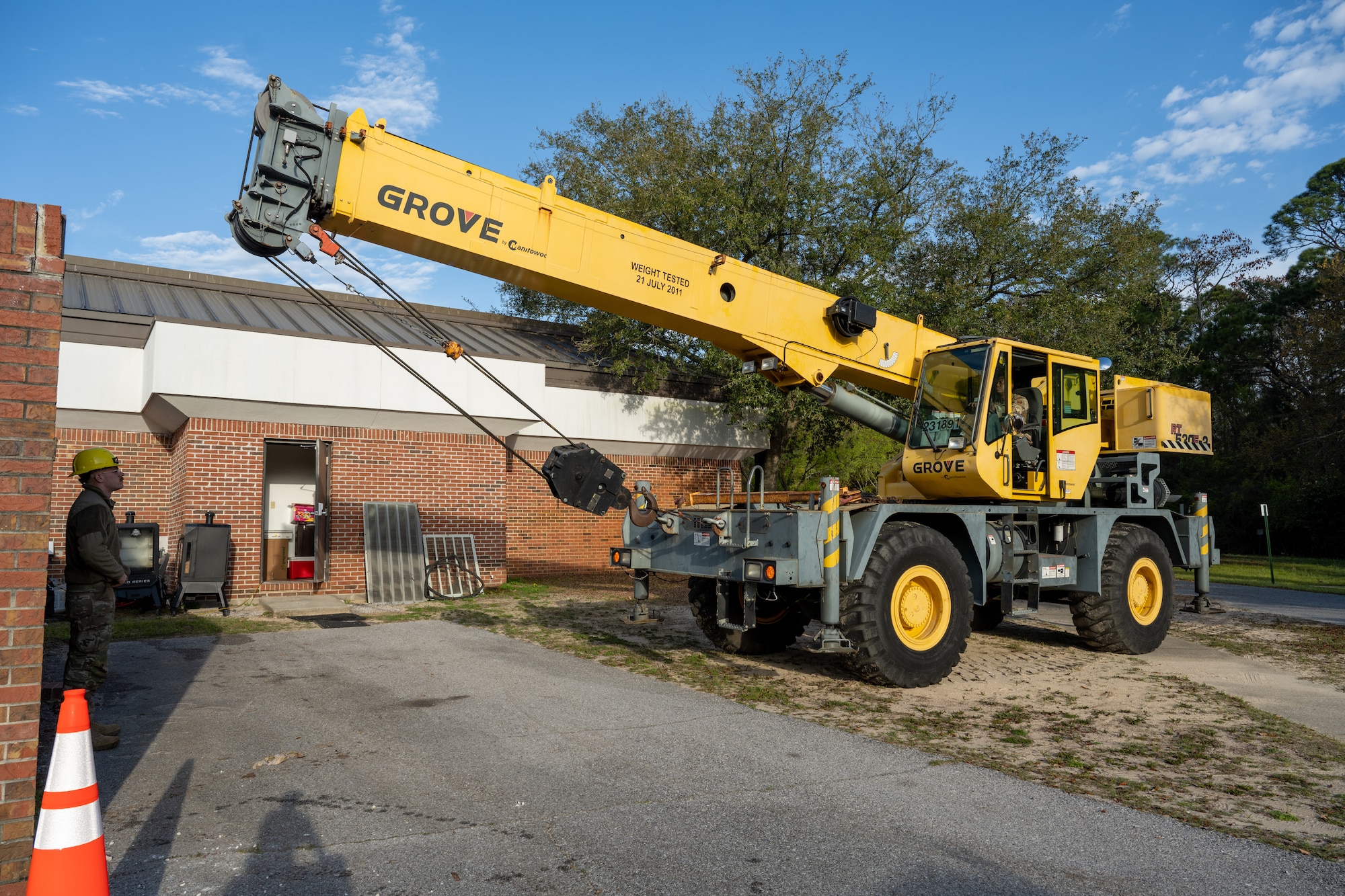 U.S. Air Force Airmen from the 1st Special Operations Civil Engineer Squadron pavement and construction equipment shop position a crane while replacing a chiller at Hurlburt Field, Florida, March 13, 2024. Airmen with the 1st SOCES HVAC shop, ‘Dirt Boyz’ and the 823rd Red Horse Squadron, worked together to ensure the new HVAC system for the Chapel was properly and safely replaced. (U.S. Air Force photo by Senior Airman Alysa Calvarese)