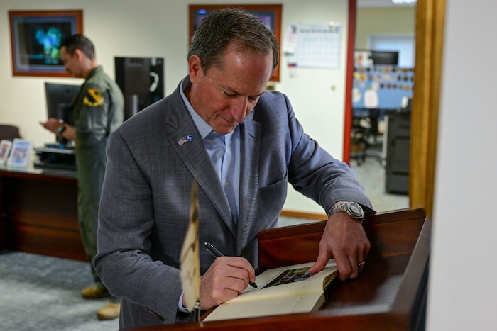 Retired Gen. David L. Goldfein, 21st Chief of Staff of the Air Force, signs the 31st Fighter Wing guestbook.