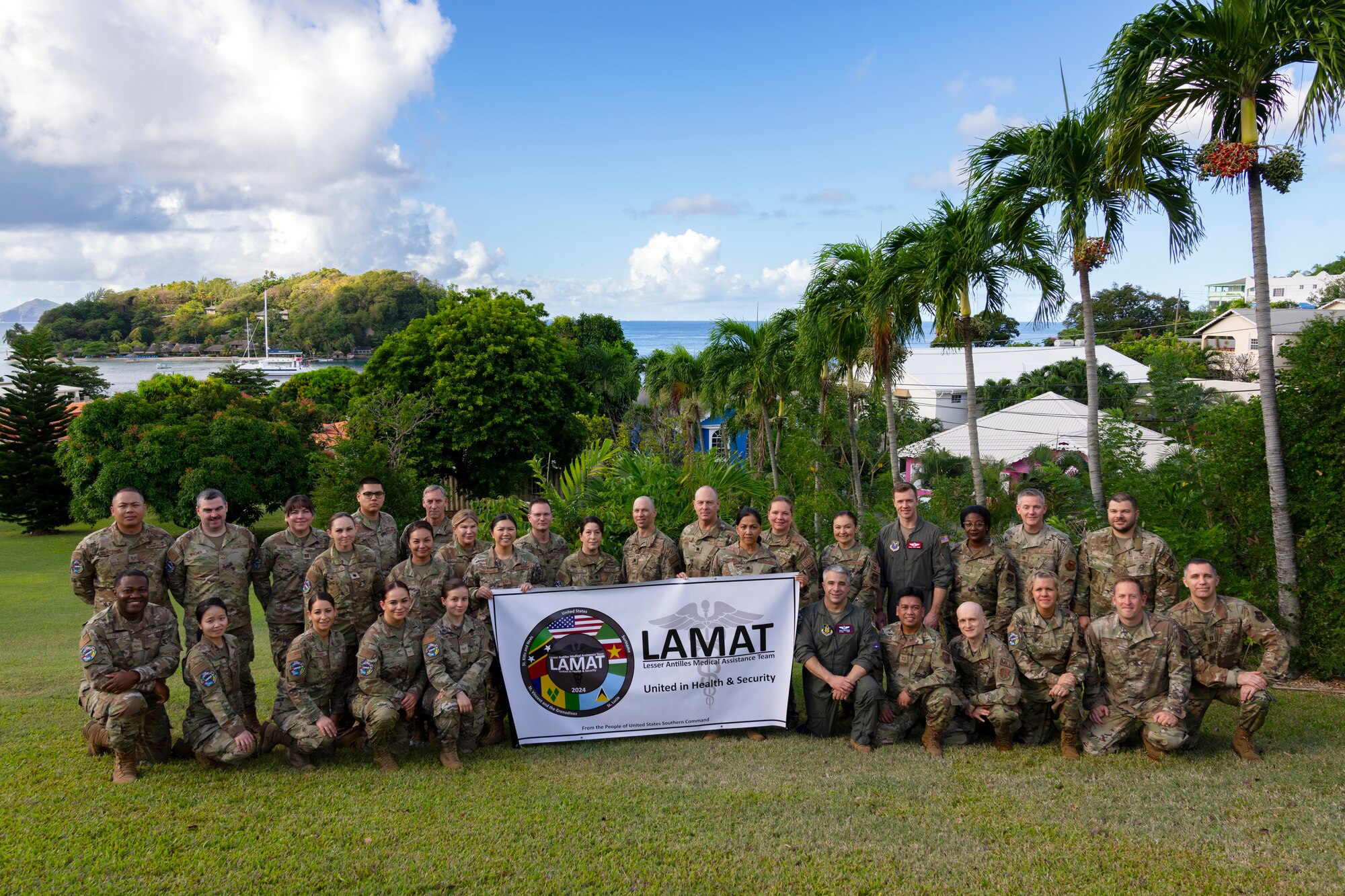 U.S. Air Force active duty and reserve personnel stand in formation for a group photo during the Lesser Antilles Medical Assistance Team mission in St. Vincent and the Grenadines, March 3, 2024. This is the first opportunity for the U.S. Southern Command directed medical team to collaborate and partner with St. Vincent medical professionals to deliver support and resources to the island nation and its healthcare system. (U.S. Air Force photo by Tech. Sgt. Rachel Maxwell)