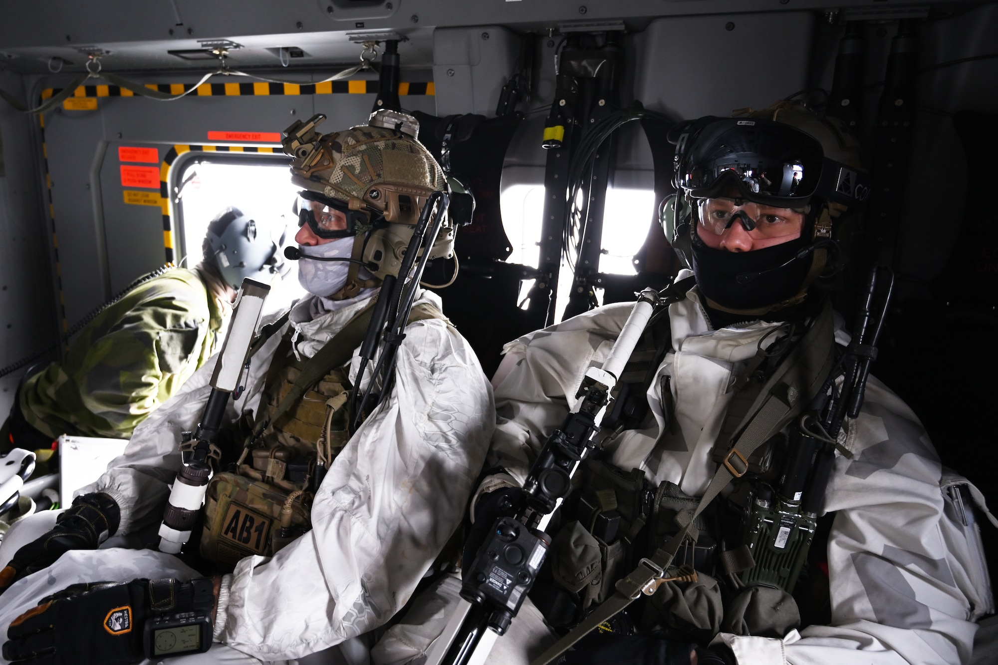 An airman flies in a helicopter.