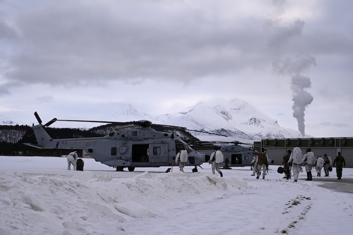 Airmen and Swedes prepare to fly in helicopters.