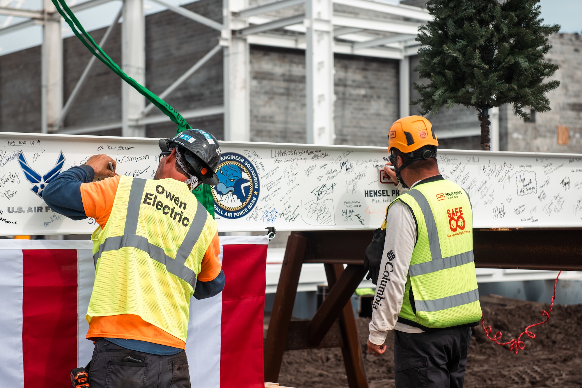 Construction workers sign a support beam.