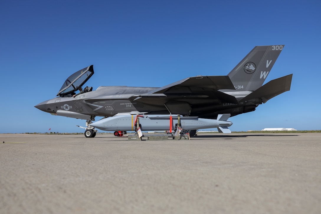 A U.S. Marine Corps F-35C Lightning II assigned to Marine Fighter Attack Squadron (VMFA) 314, Marine Aircraft Group 11, 3rd Marine Aircraft Wing, and two AGM-154 Joint Standoff Weapon (JSOW) are staged at Marine Corps Air Station Miramar, California, March 8, 2024. The JSOW is a fire-and-forget medium-range precision guided weapon intended for use against soft targets. This loading of the JSOW is the first loading of the weapon system on the F-35C and the first time being loaded in a garrison environment in nearly 20 years. (U.S. Marine Corps photo by Sgt. Sean Potter)