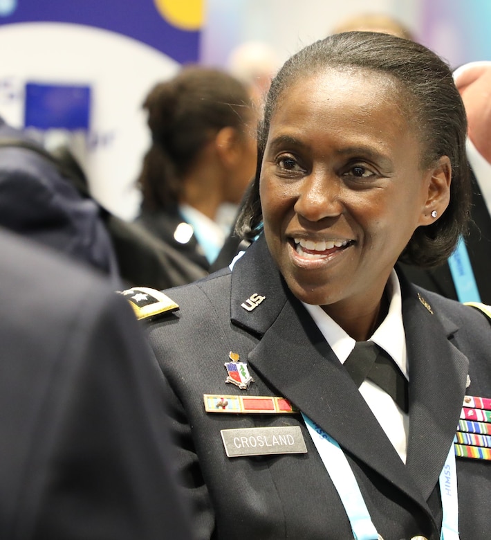 A woman smiles while in a military uniform.
