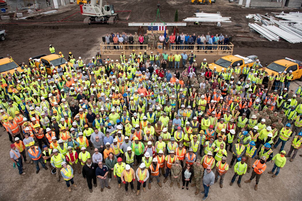 A group of people pose for a photo on a construction site.