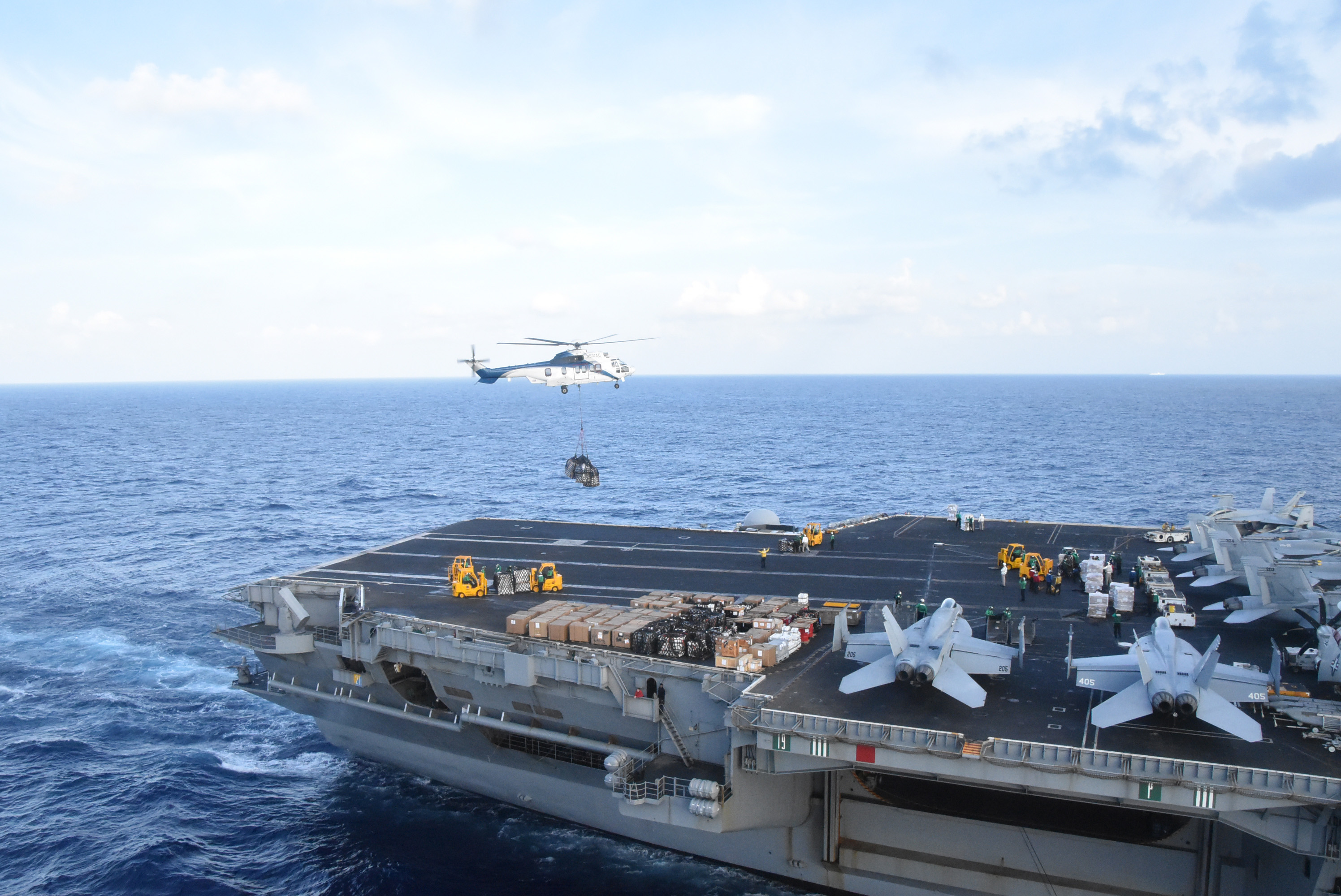 An EC-225 Super Puma helicopter from dry cargo and ammunition ship USNS Charles Drew (T-AKE 10) approaches the flight deck of Nimitz-class aircraft carrier USS Theodore Roosevelt (CVN 71)